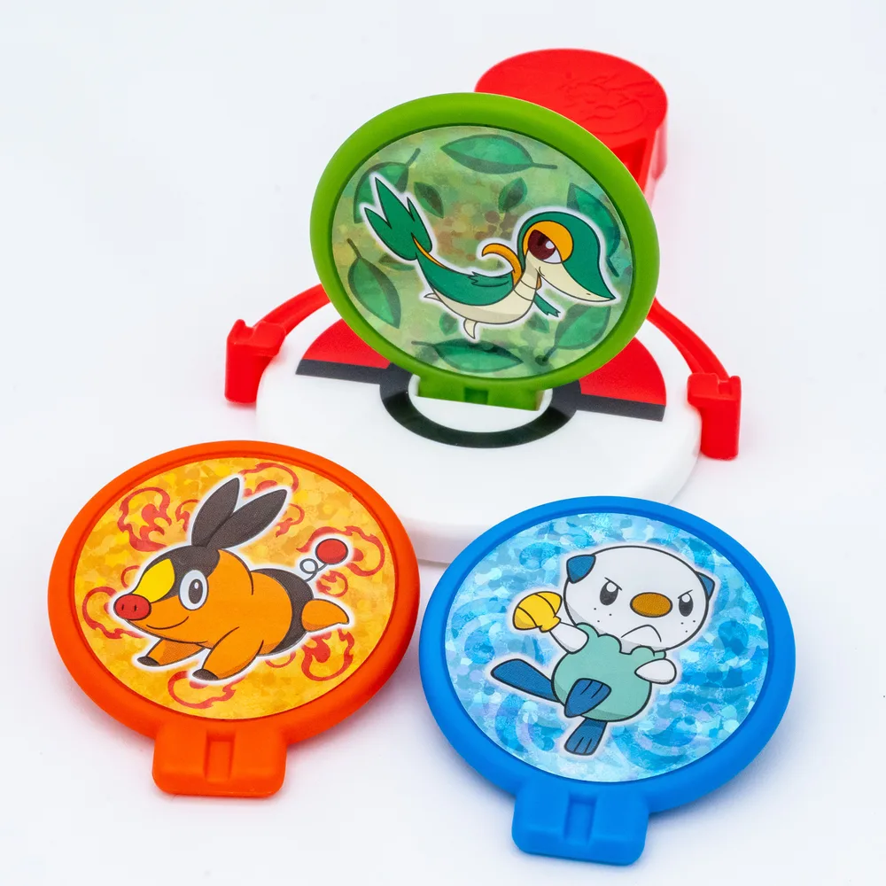 Detail of the Squeeze Shooting toy showing the red launching arm mounted on the Poké Ball patterned base